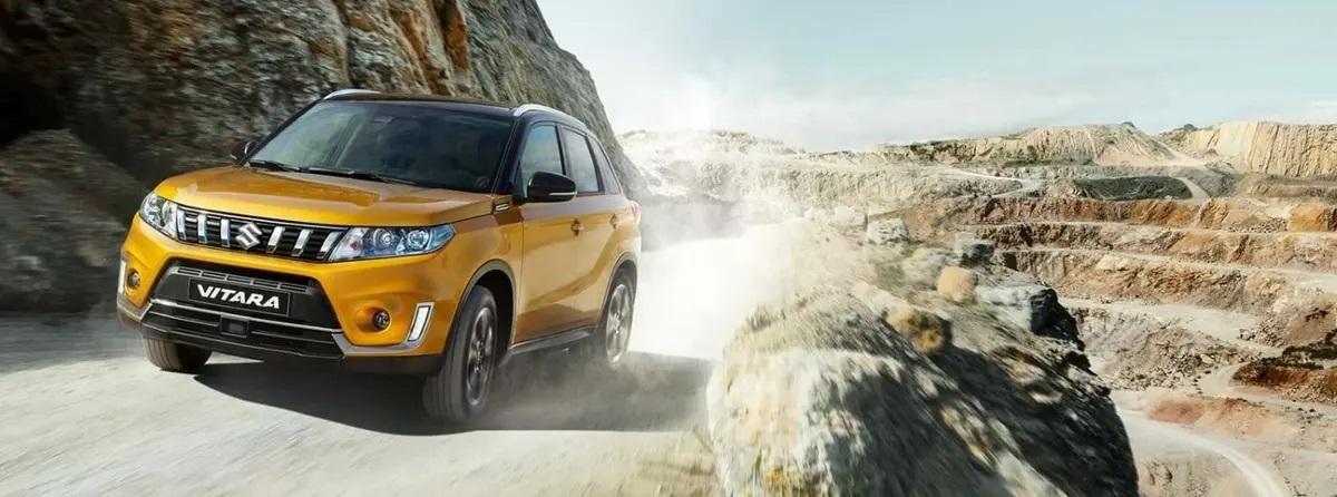 Yellow Suzuki Vitara driving up dirt track
