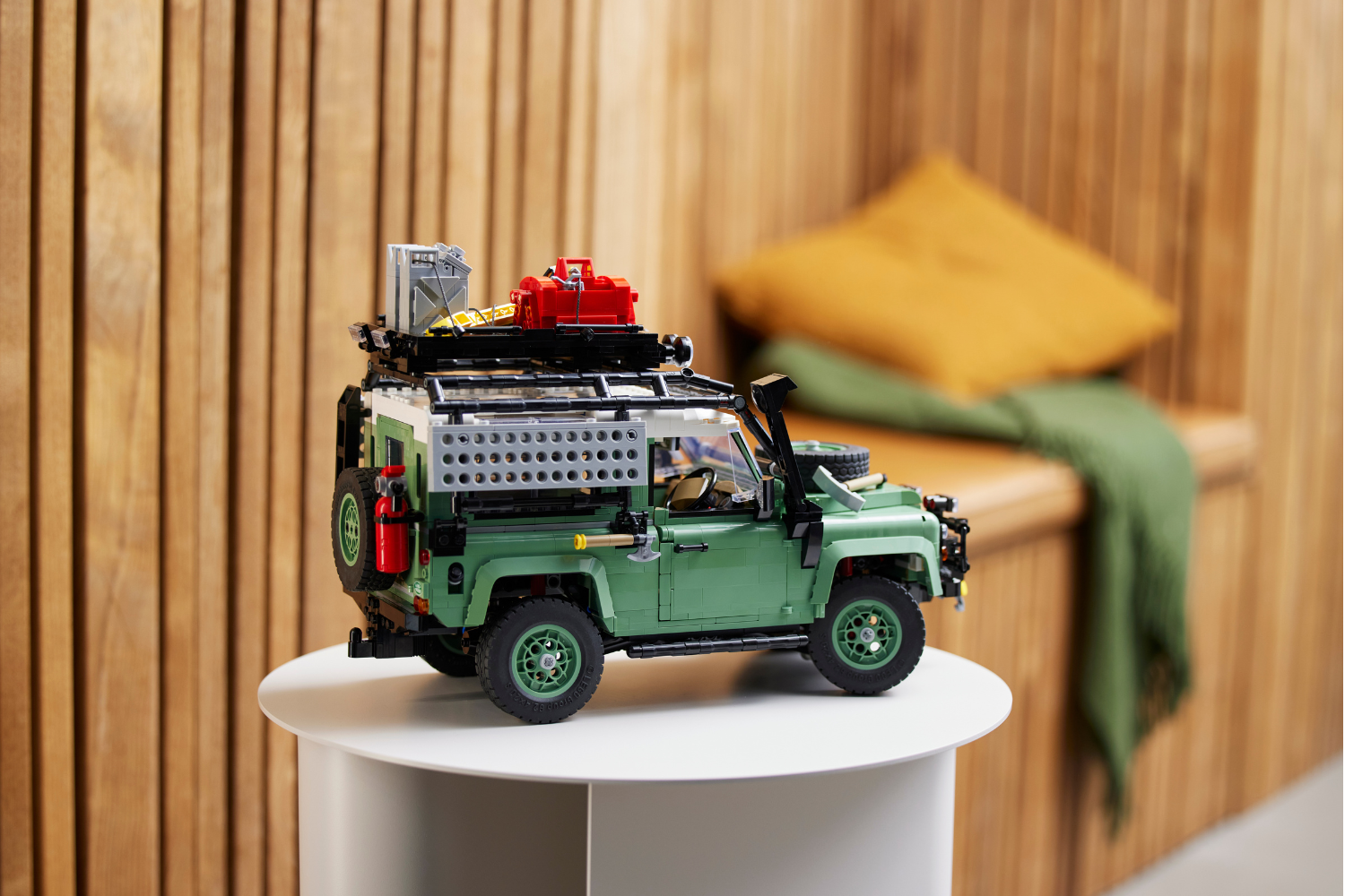 LEGO Land Rover Defender model with roof rack and expedition accessories.