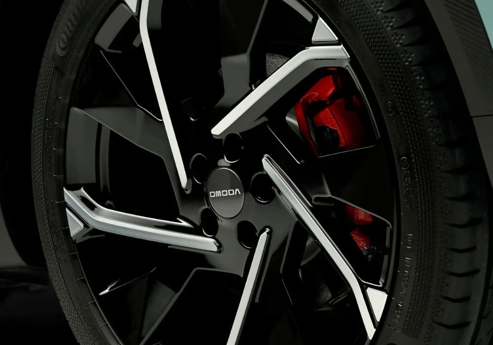 OMODA alloy wheel with multi-spoke design and visible red brake caliper.