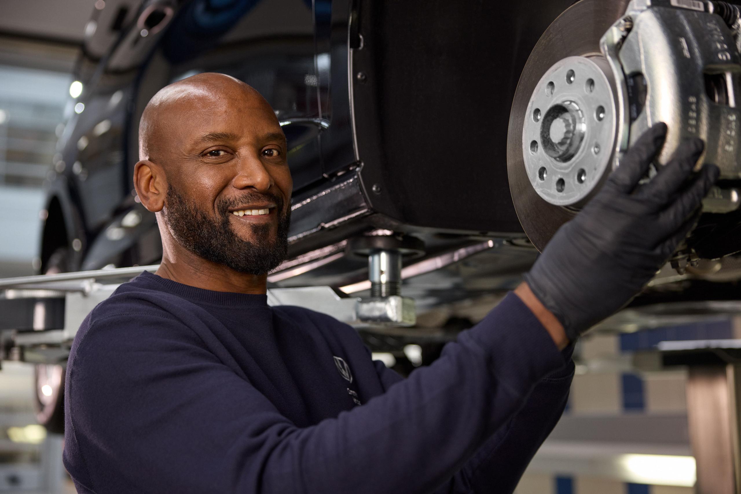 Volkswagen Mechanic Inspecting Brake Disc