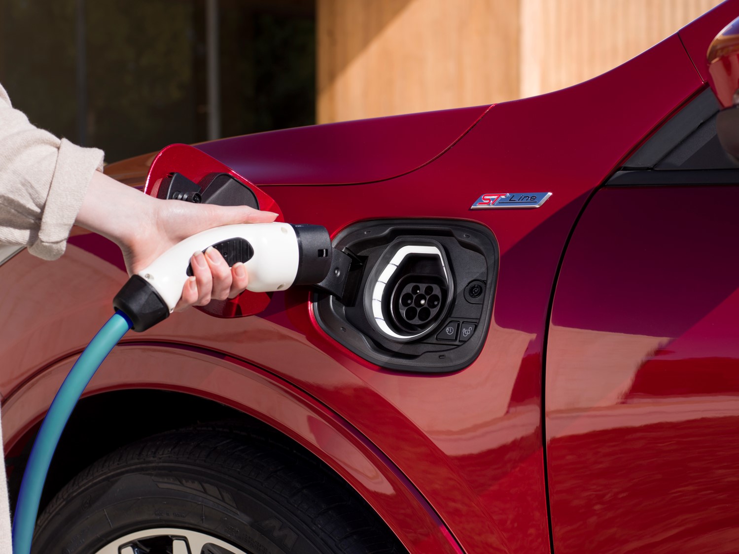 Close-up of an electric car plugged into a charging point.