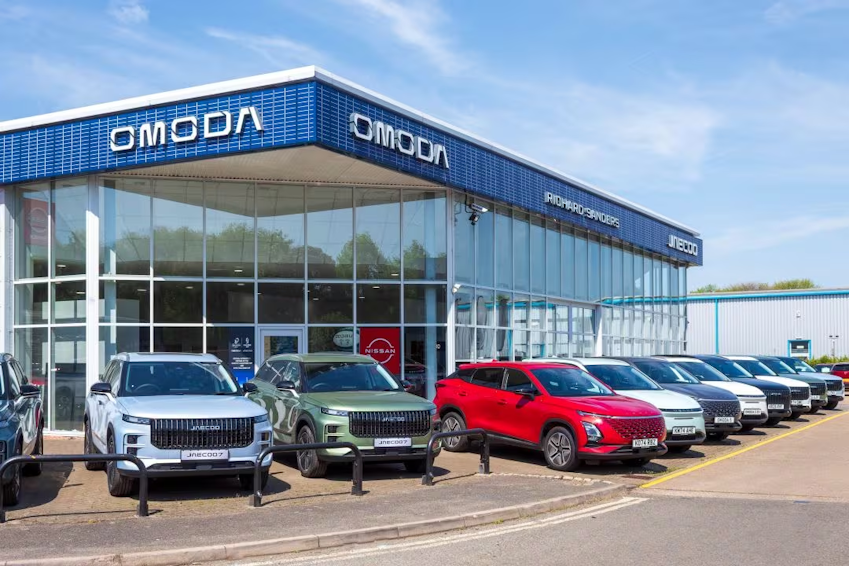 Exterior view of Omoda dealership with multiple Omoda models parked outside and showroom signage visible.