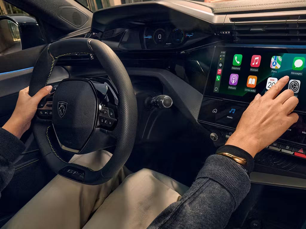 Interior view of the new Peugeot 308 i-Cockpit, featuring the compact leather steering wheel, digital instrument cluster and central touchscreen displaying Apple CarPlay connectivity.