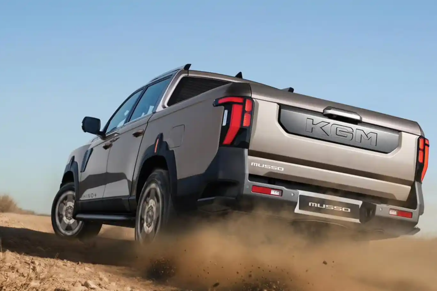 KGM Musso Rhino pickup truck driving through rugged terrain