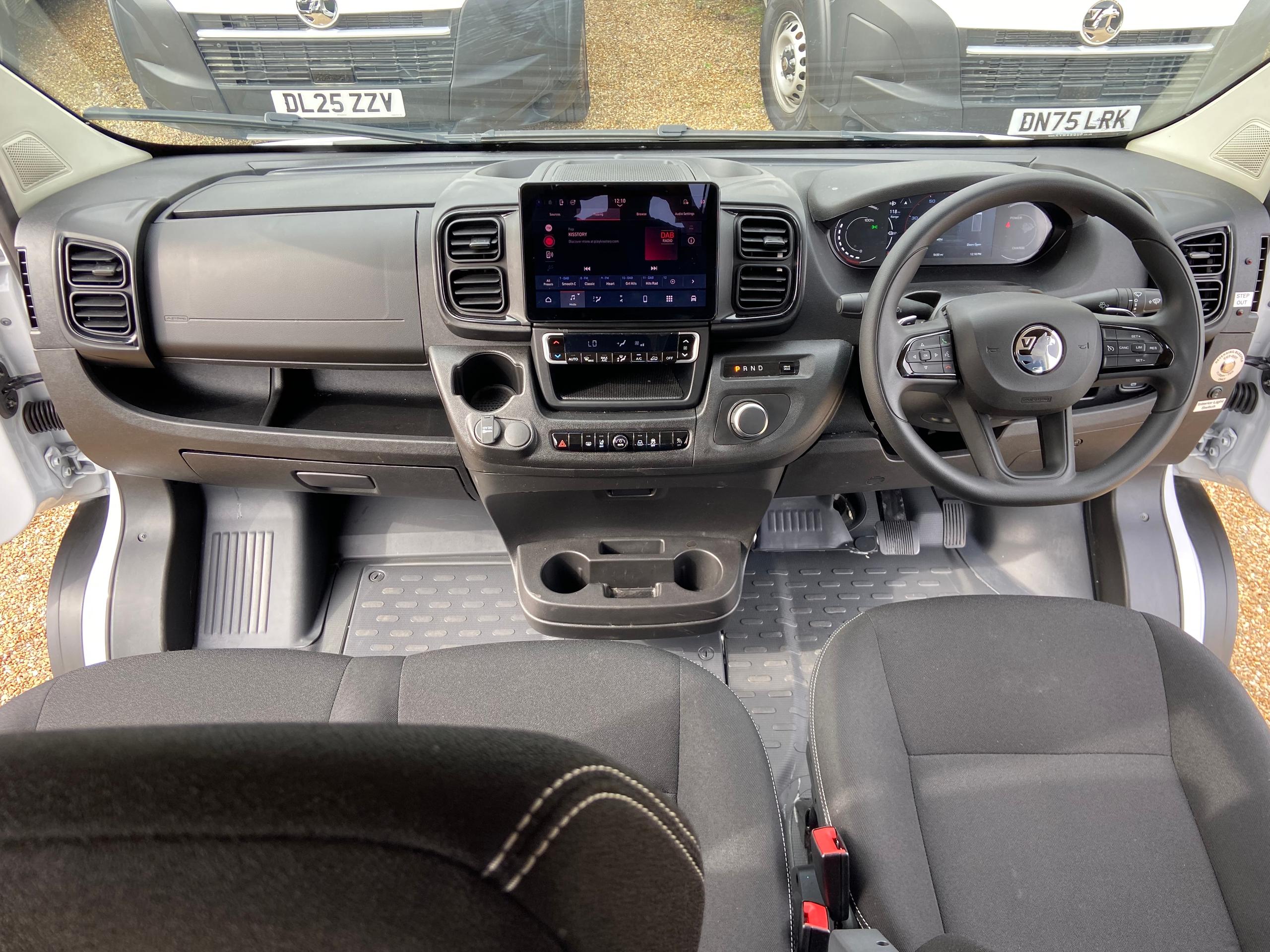 Driver’s cockpit of CVMinibus with steering wheel, dashboard and central touchscreen display.