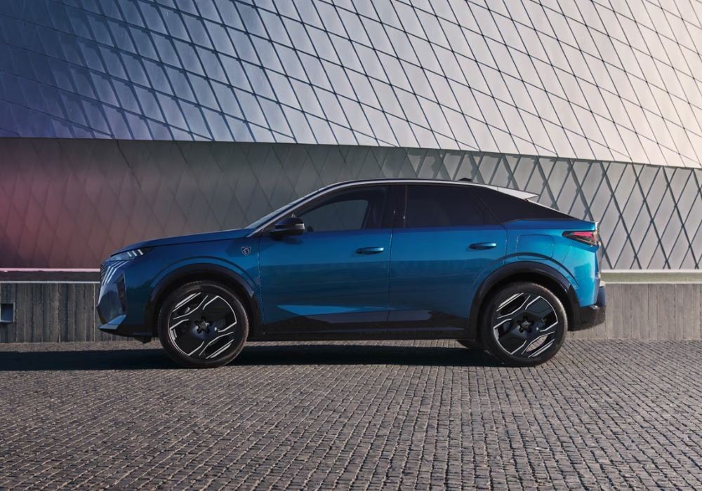 Peugeot E-3008 electric SUV in blue shown in full side profile parked in front of a modern geometric wall.
