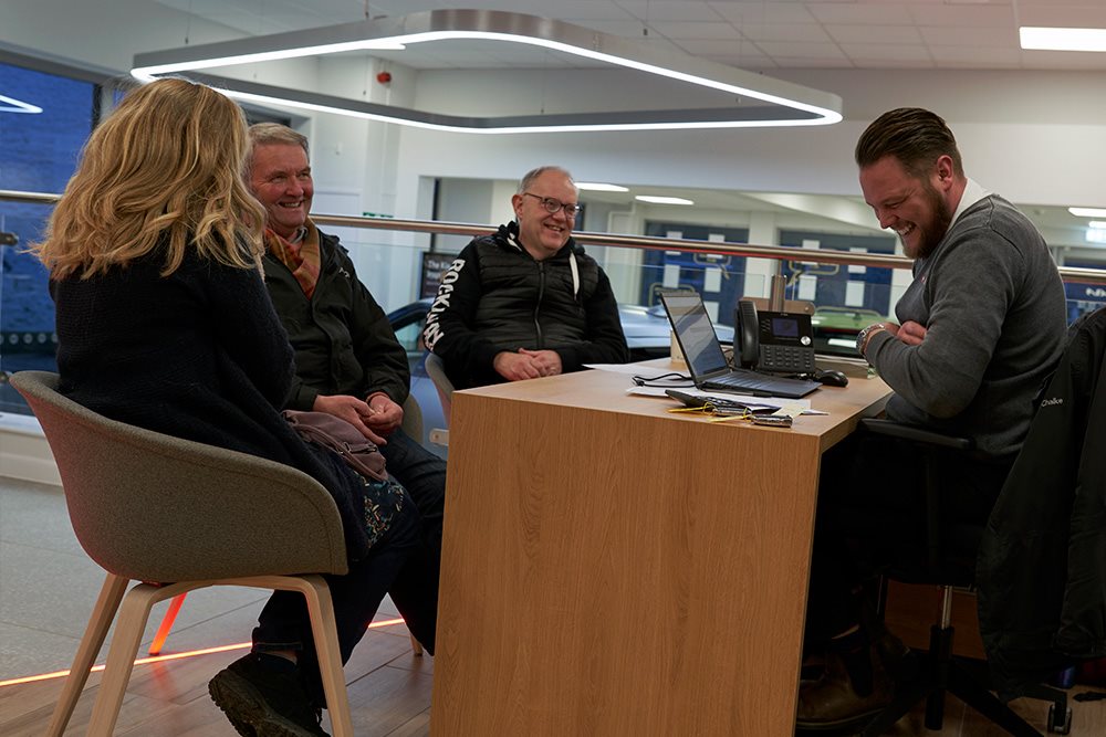 man talking to customers in showroom