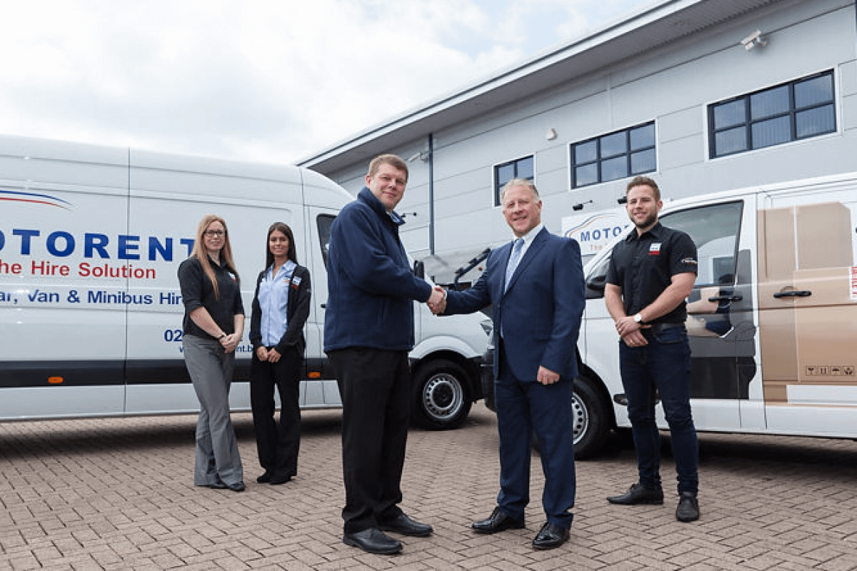 men shaking hands in front of new vans