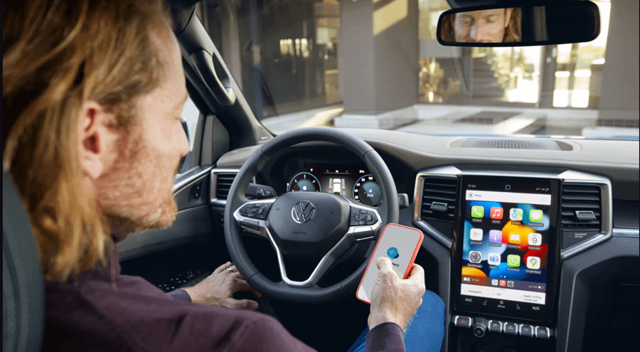 Person sat in New Volkswagen Amarok on phone using infotainment system