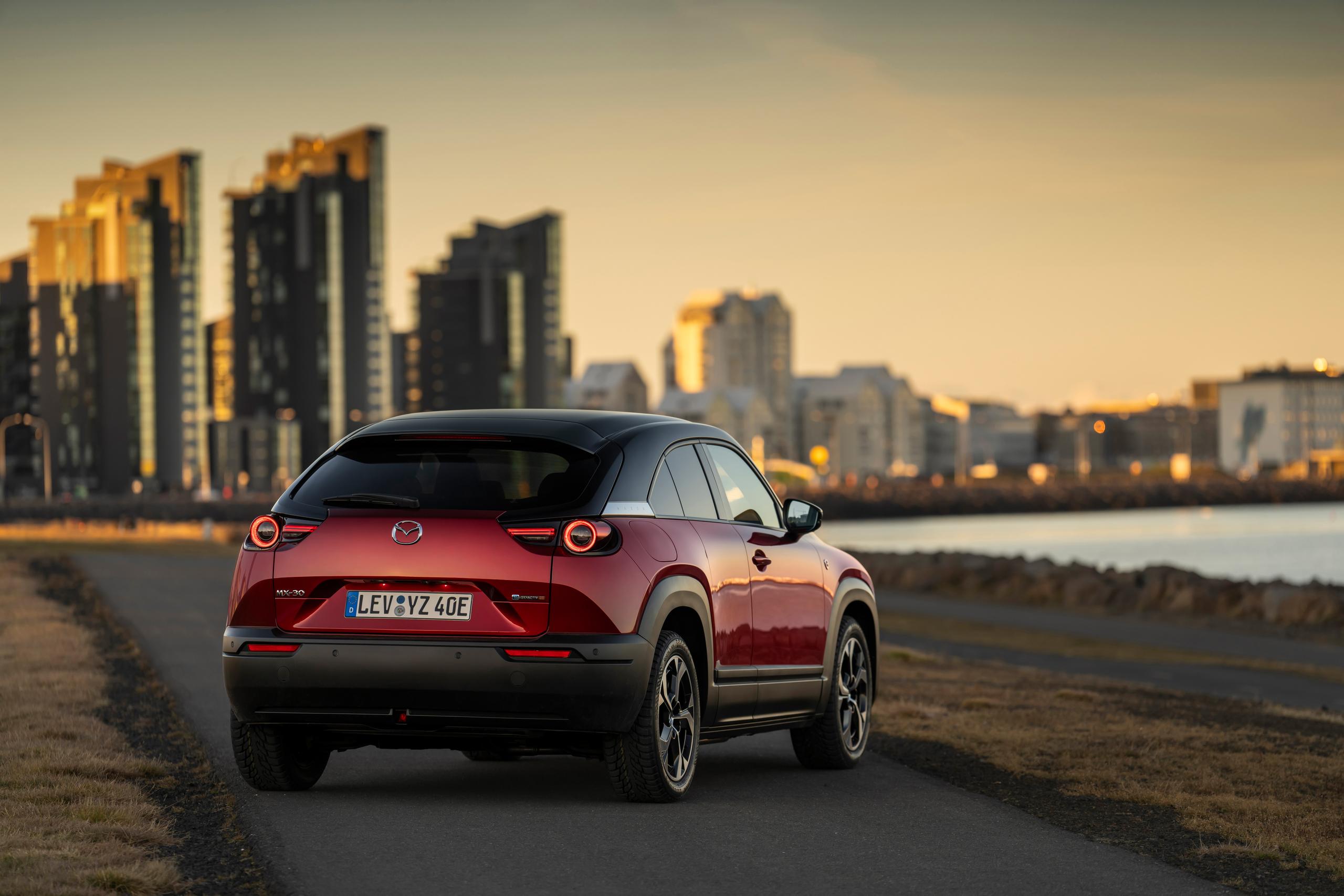 Red MX-30 parked facing a lake