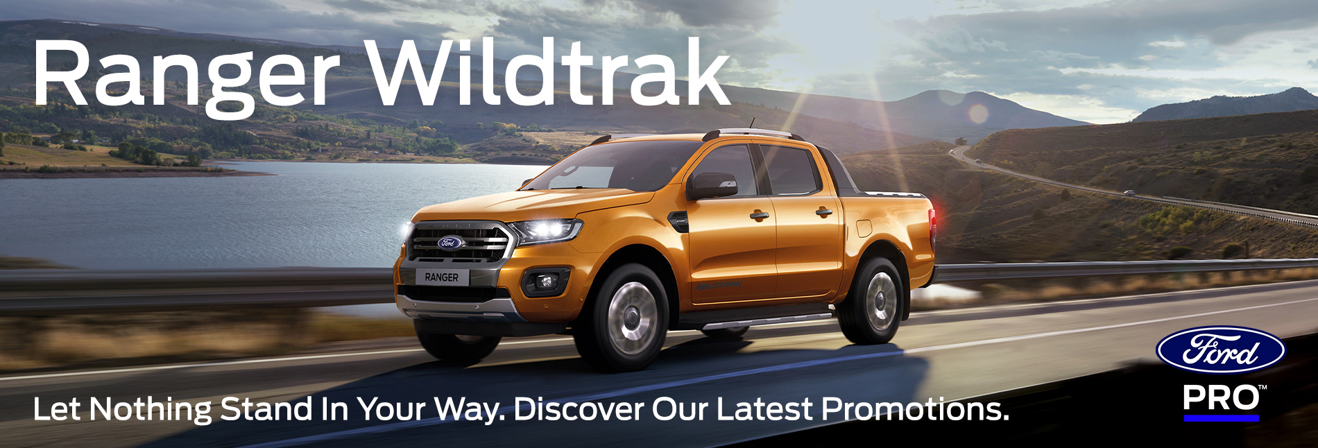 A banner advertising the new Ford Ranger Wildtrak. The Ranger Wildtrak is driving along a scenic road with a lake and mountains in the background. Underneath is the caption "Let nothing stand in your way. Discover our latest promotions"