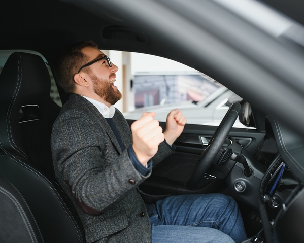 Man happy in driver seat of car