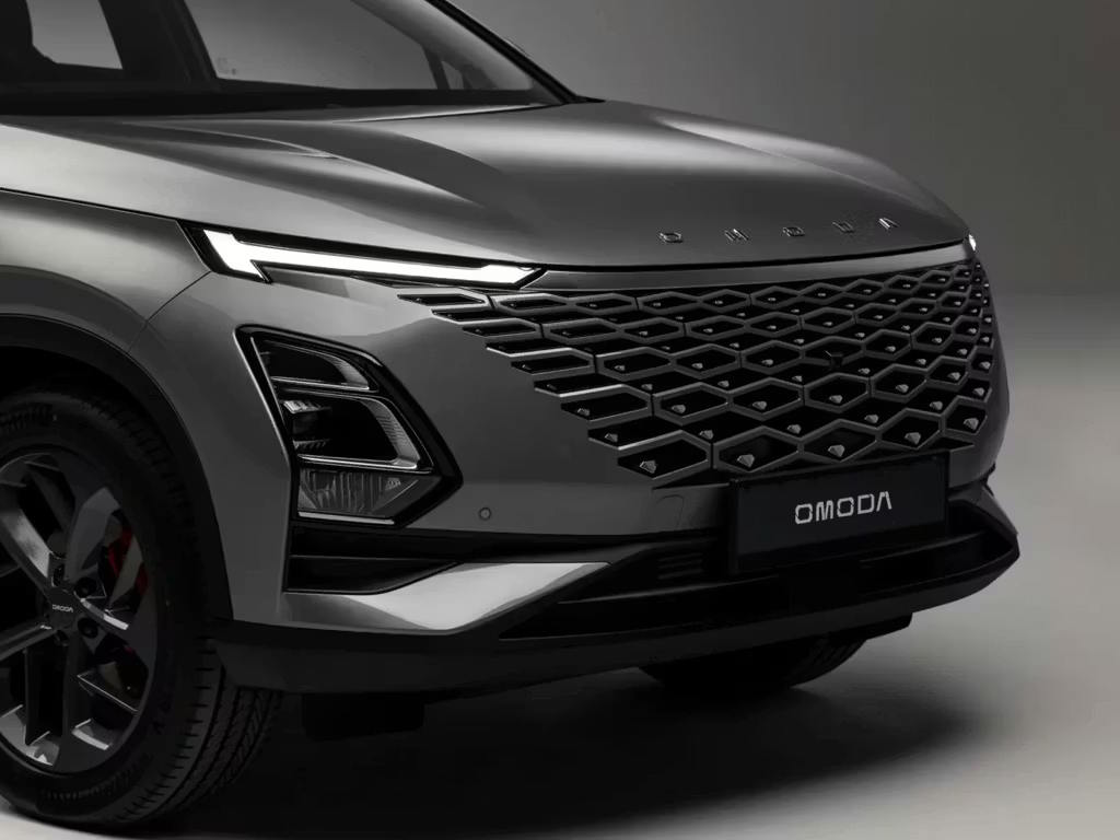 Front three-quarter close-up of the Omoda 5 SUV in grey, highlighting the striking LED daytime running lights, bold honeycomb grille and angular front bumper designFront three-quarter close-up of the Omoda 5 SUV in grey, highlighting the striking LED daytime running lights, bold honeycomb grille and angular front bumper design