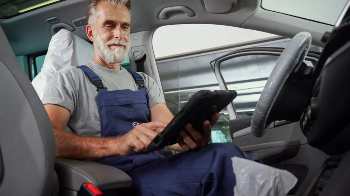 Volkswagen Mechanic Sat In VW vehicle with a iPad