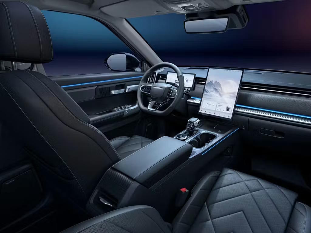 Interior view of the Jaecoo 7 SHS, featuring quilted black leather seats, dual-screen infotainment system with rotating display, ambient blue lighting and modern centre console.