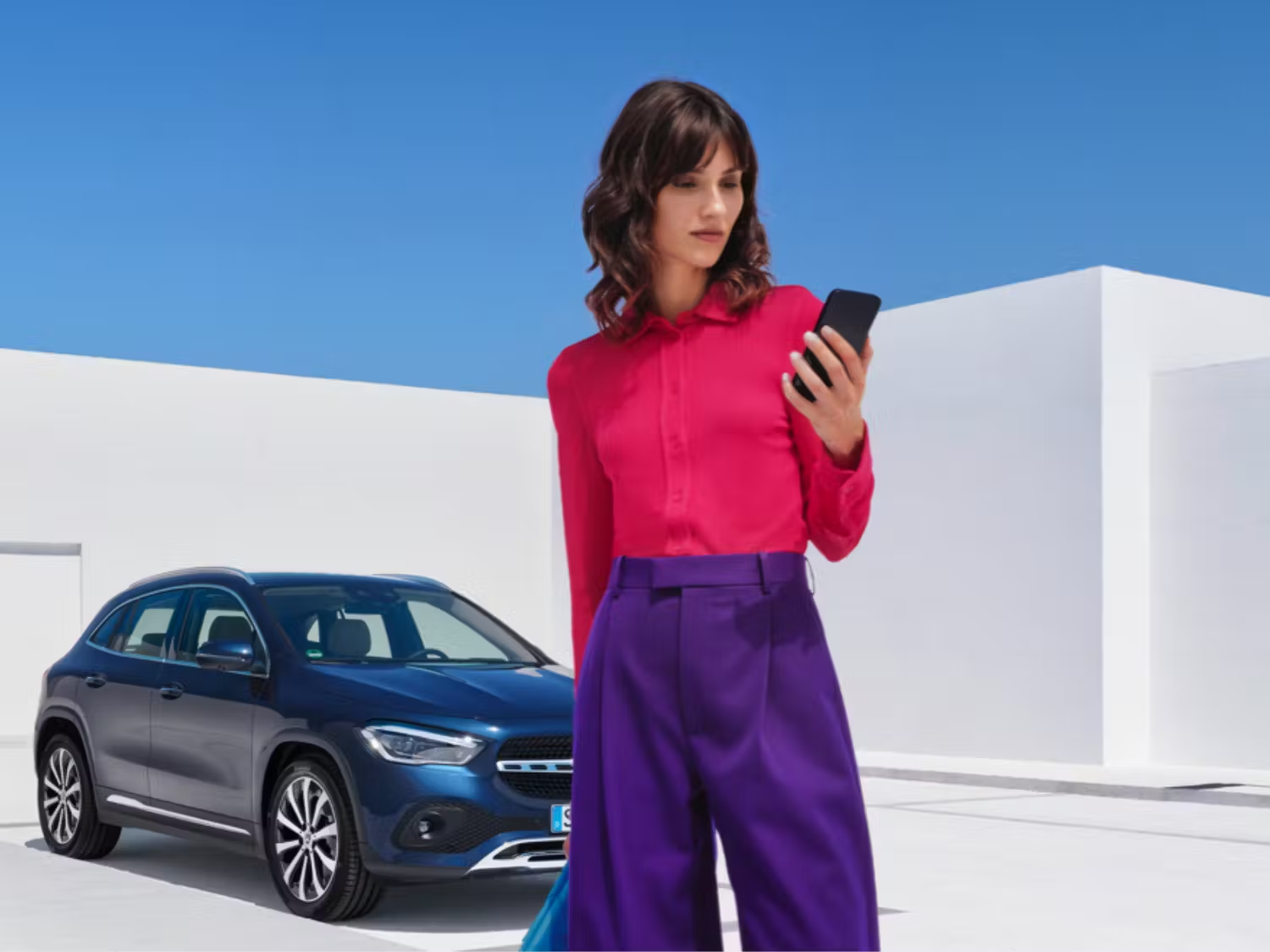 Person on Smartphone in front of Blue Mercedes-Benz Vehicle