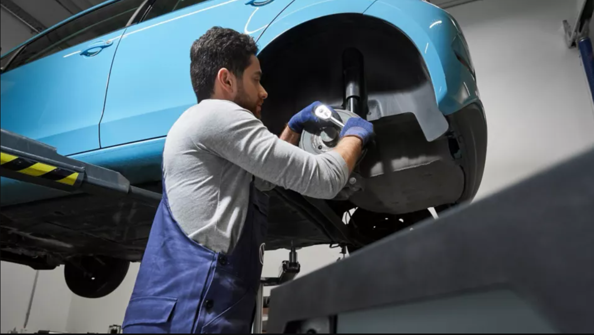 VW Mechanic Working on Wheel
