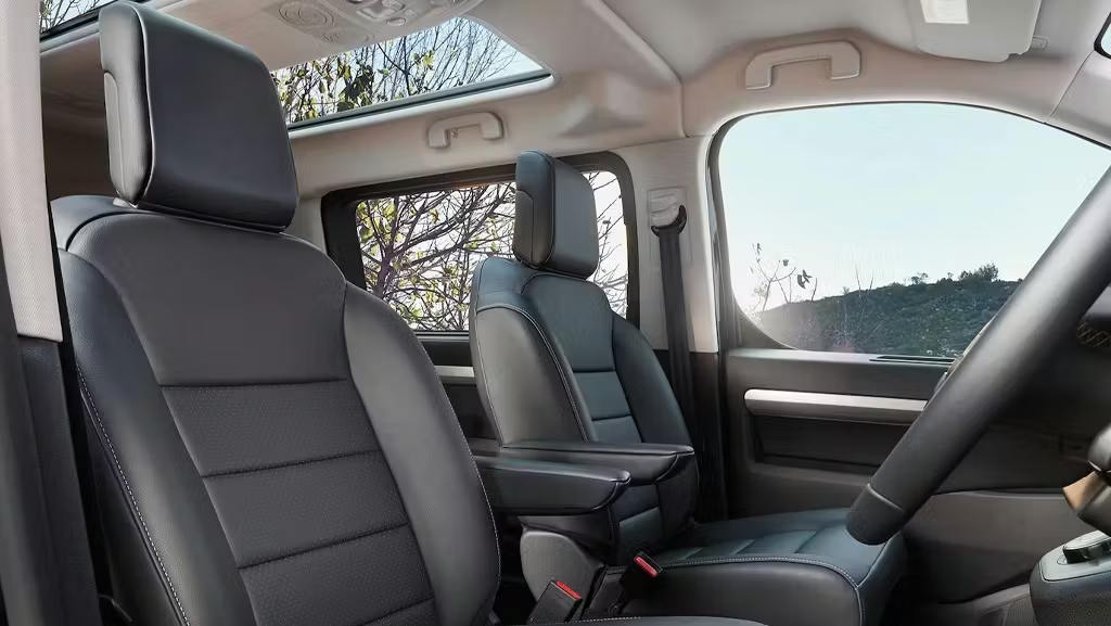 Interior of a Vauxhall Vivaro Life featuring comfortable front seats and a panoramic glass roof.