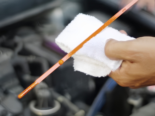Checking the engine oil level using the dipstick during routine maintenance.