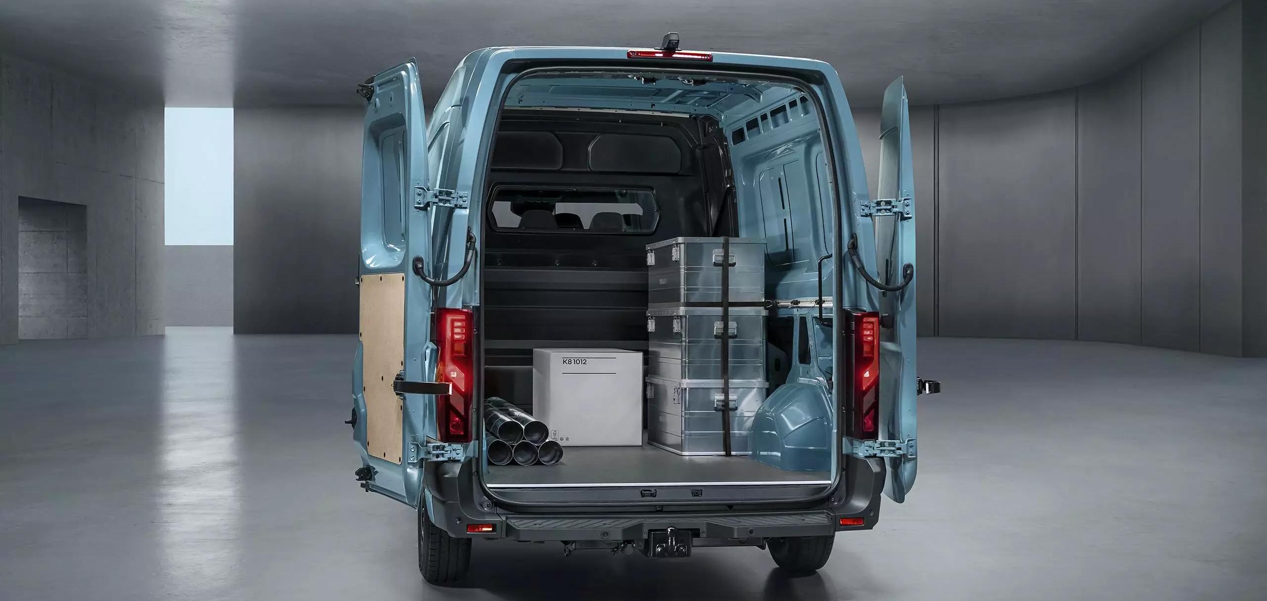 Rear view of Renault Master van with doors open displaying organised storage area with boxes and equipment.
