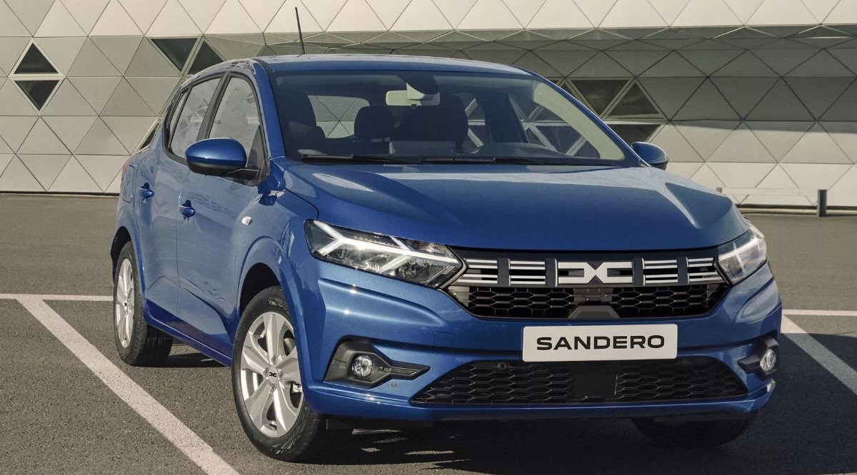 Blue Dacia Sandero parked in a modern car park outside a contemporary building.
