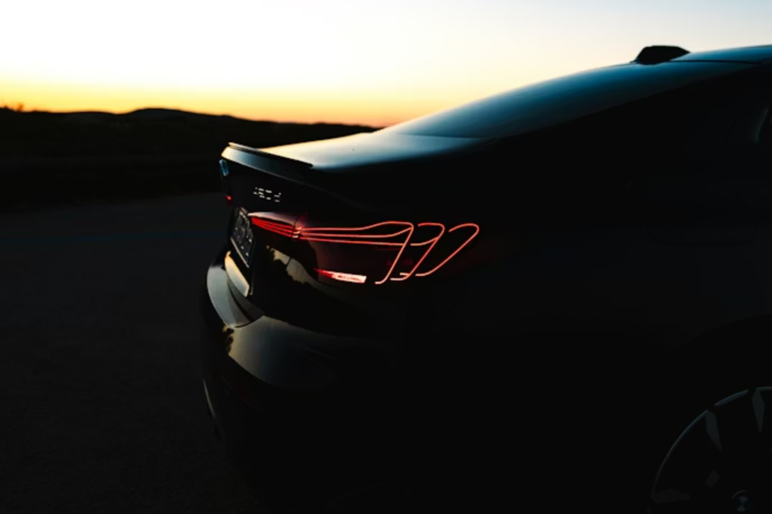 BMW rear LED tail light illuminated at sunset.