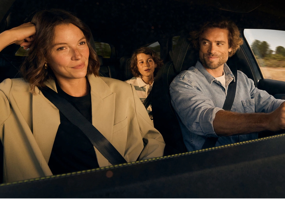 Interior of Peugeot 308 SW showing a family with a driver, front passenger, and child in the back seat during a drive.