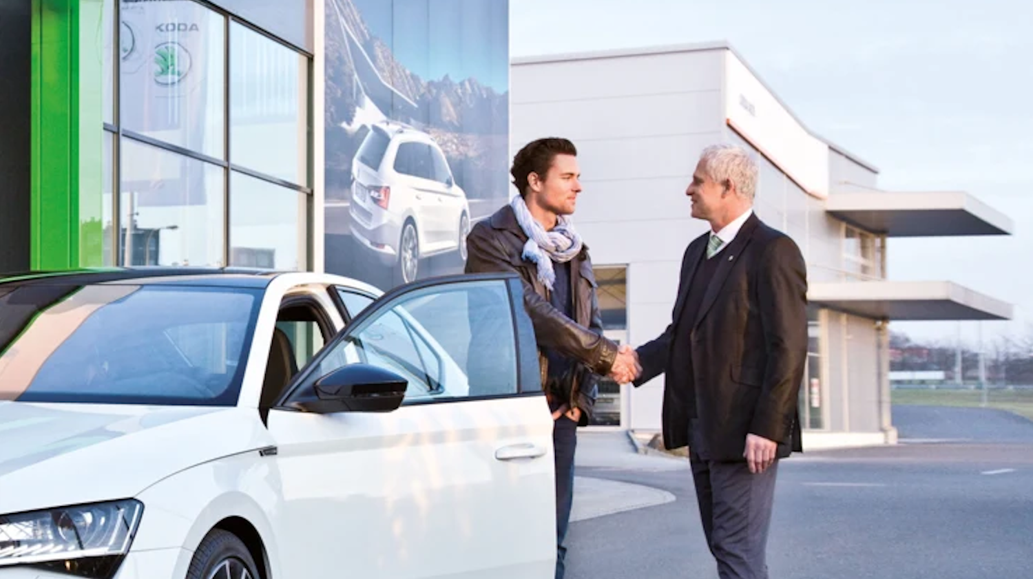 White SKODA with two people next to it shaking hands