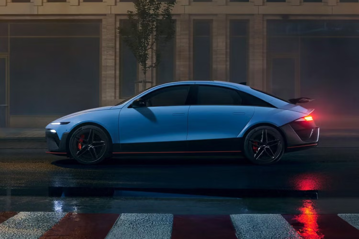 Side exterior of a blue Hyundai IONIQ 6 with tail lights on