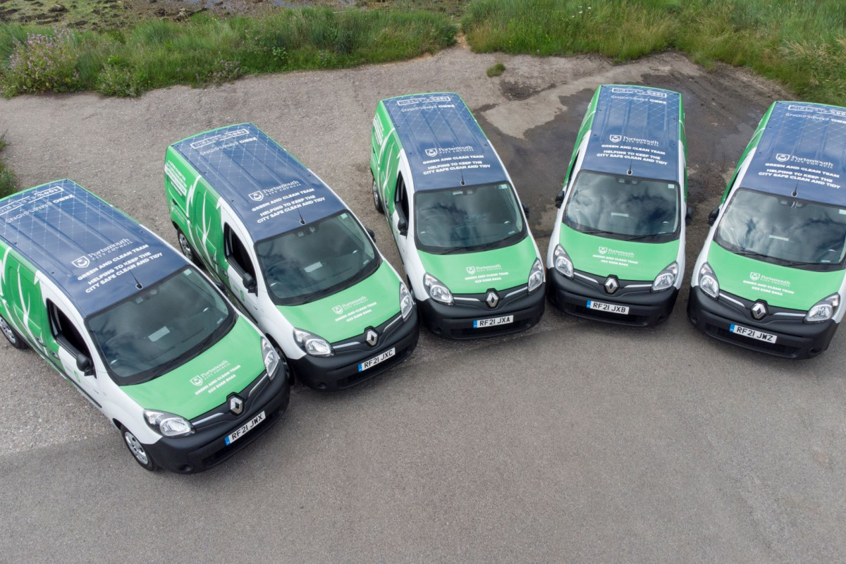 Green vans parked up next to eachother.