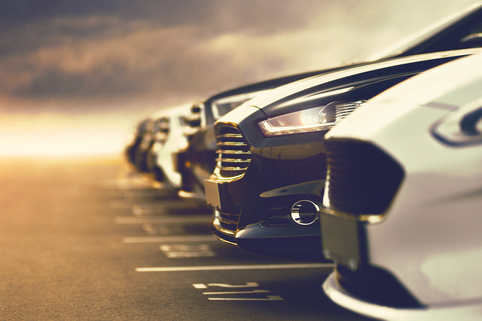 Cars lined up in a car lot.
