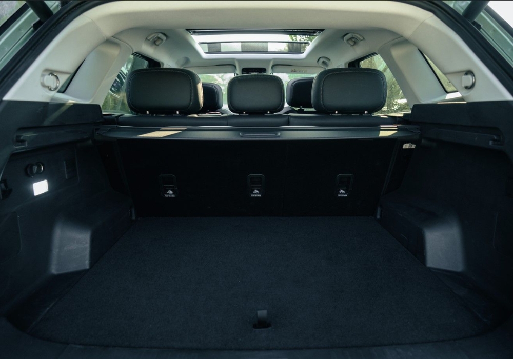 Spacious rear cargo area of the Jaecoo 7 with rear seats upright and a panoramic sunroof above.