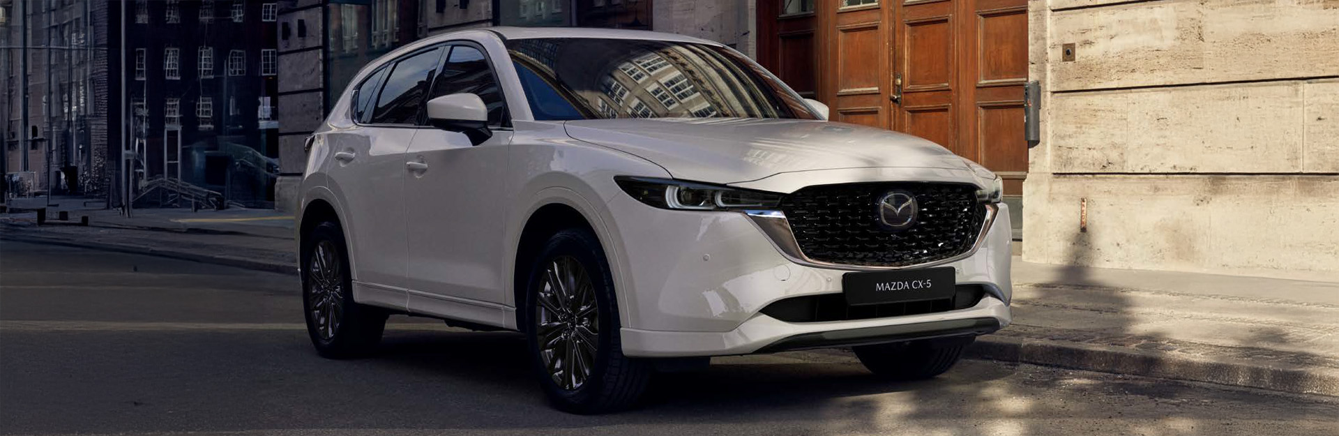 White mazda cx 5 driving through urban street