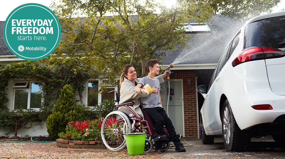 Mother in wheelchair washing motability car with son