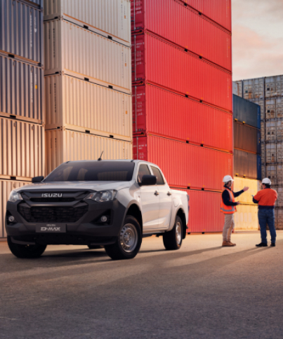 white isuzu by the containers