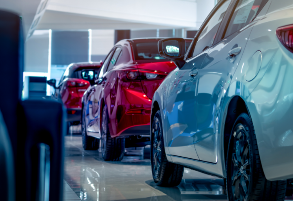 3 cars lined up one behind another. Silver car at the back followed by 2 red cars.