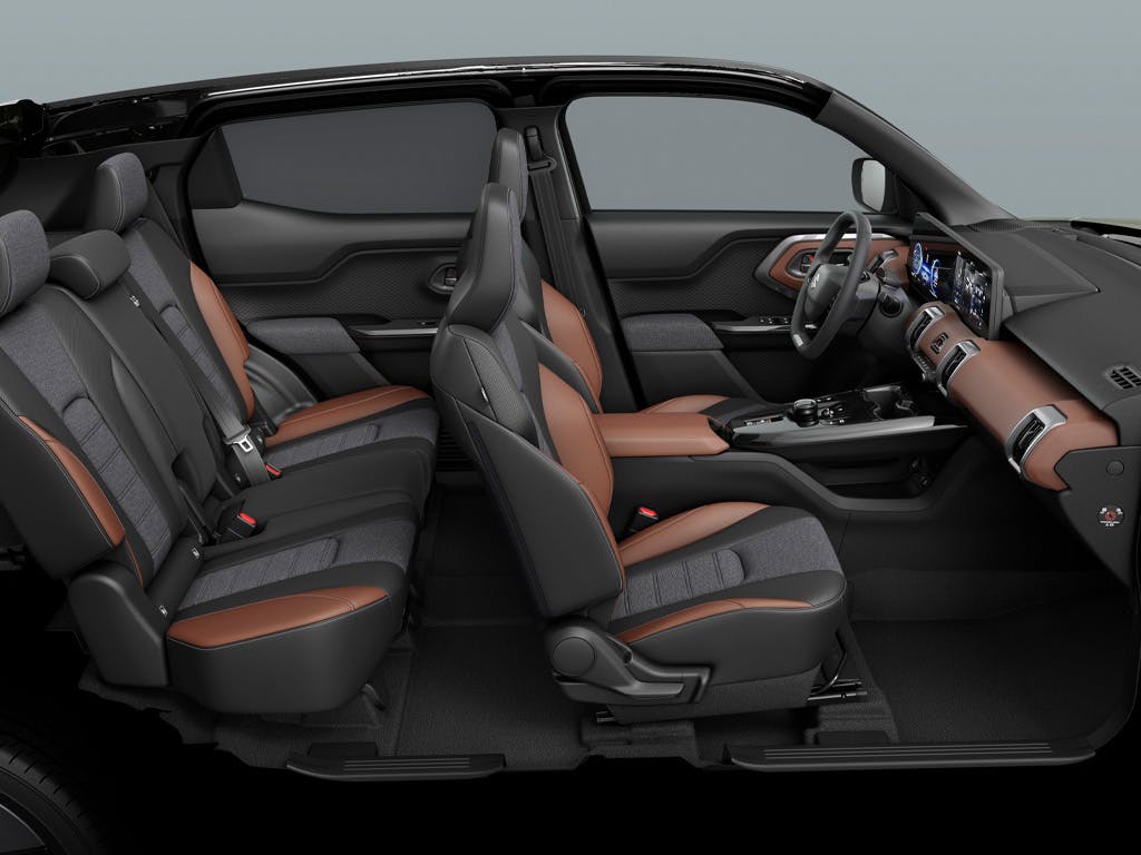 Cutaway side view of the Suzuki e Vitara interior, revealing the spacious five-seat cabin with two-tone black and tan leather upholstery, digital displays and modern dashboard design.