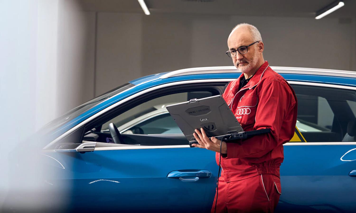 Mechanic Inspecting A Vehicle Via a Laptop