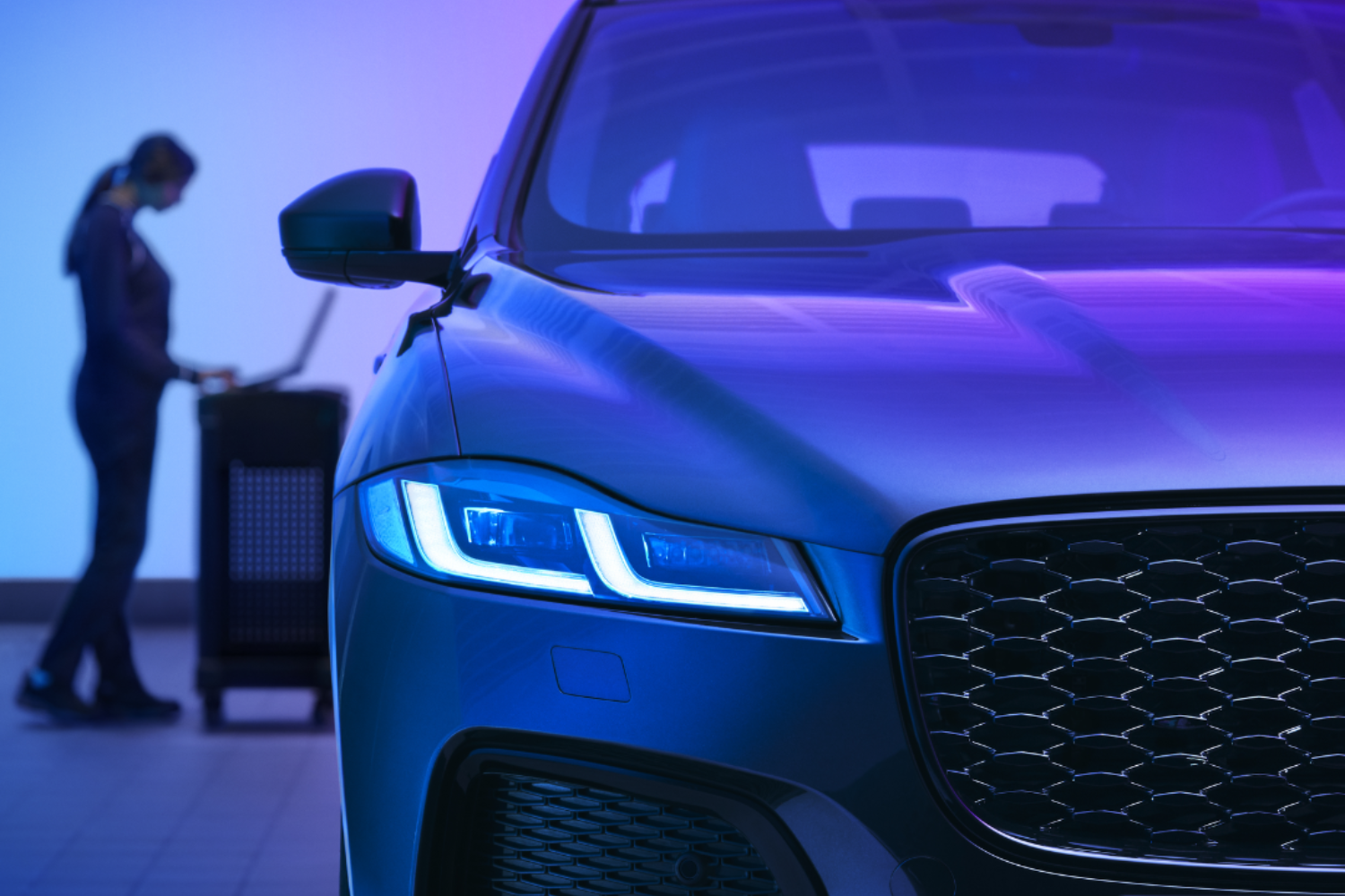 Jaguar front end with LED headlight illuminated in workshop.
