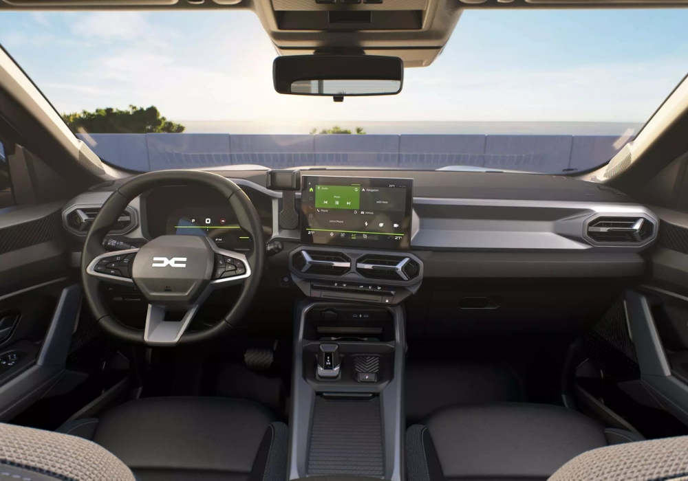 Dacia Duster interior with steering wheel and central touchscreen display, showing infotainment system and dashboard layout.