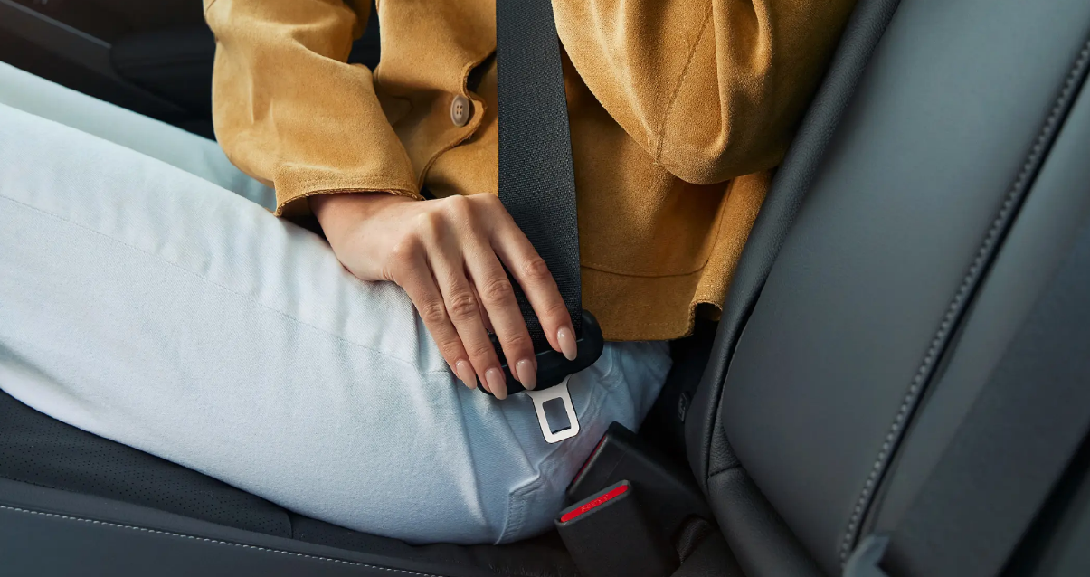 A passenger fastening the seatbelt when sat in a rear seat of a Honda Civic.
