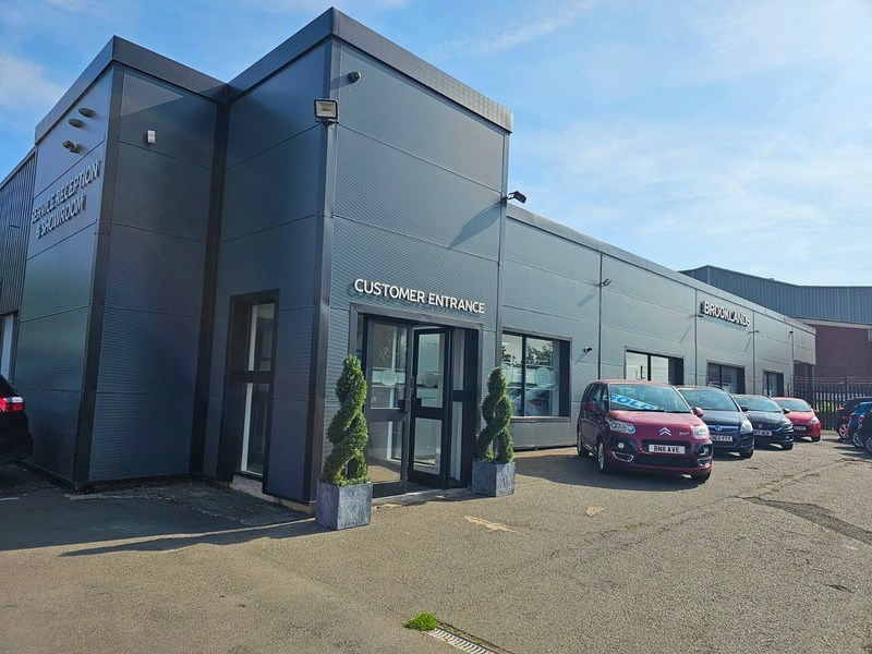 Front view of Brookland Motors dealership highlighting customer entrance.