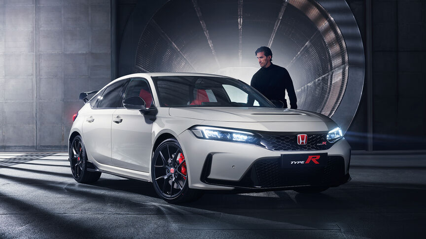 Silver Honda Civic Type R with a driver dressed in black next to it