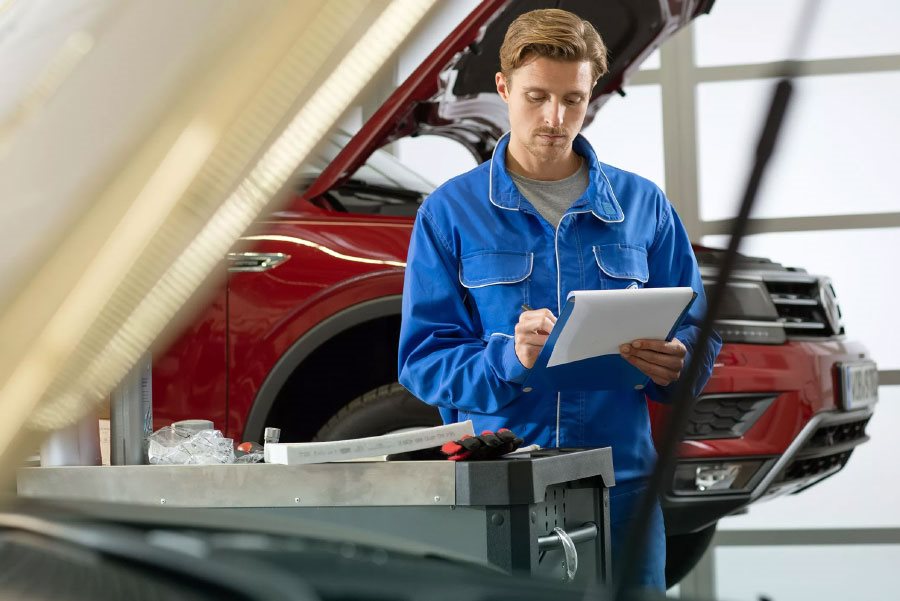 Volkswagen Mechanic Looking at Notepad