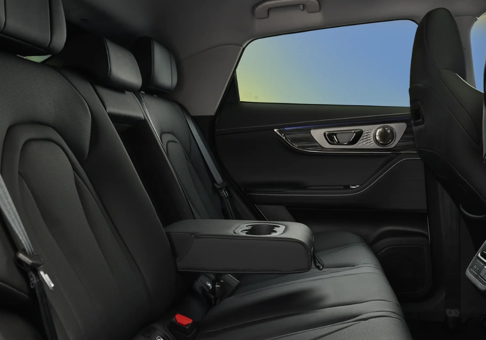 Close-up of the OMODA E5 rear seats emphasizing leather upholstery, stitching, and center armrest with cupholders.