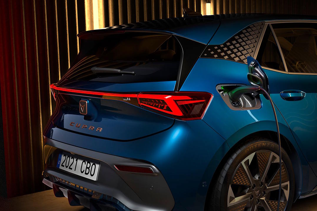 Rear view of a CUPRA Born plugged into a charger.