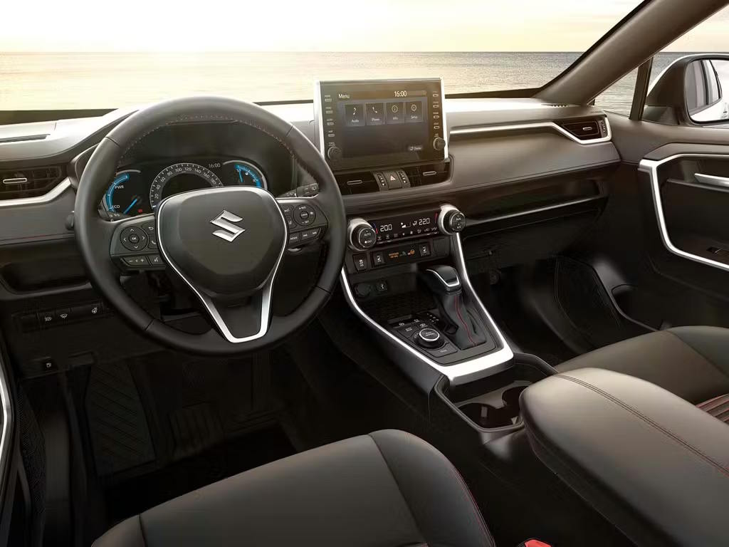 Suzuki Across interior view showcasing the driver-focused cockpit with leather-trimmed seats featuring red stitching, multifunction steering wheel, digital instrument cluster and floating touchscreen infotainment display.