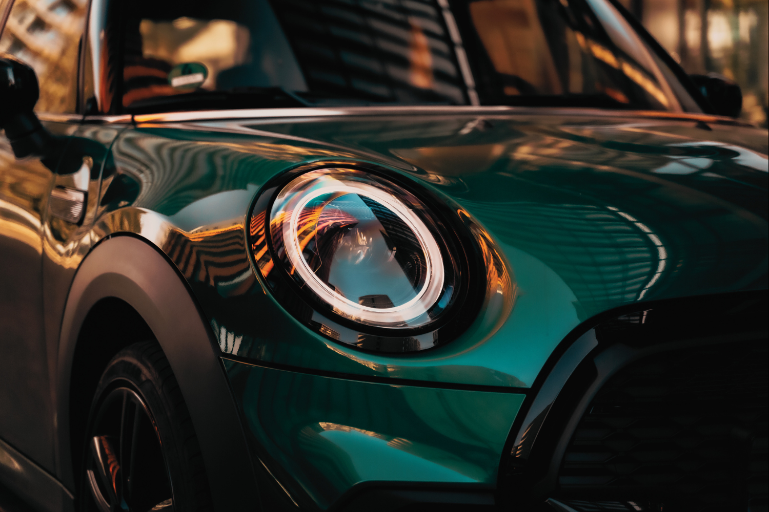 Close-up of green Mini headlight and front bodywork.