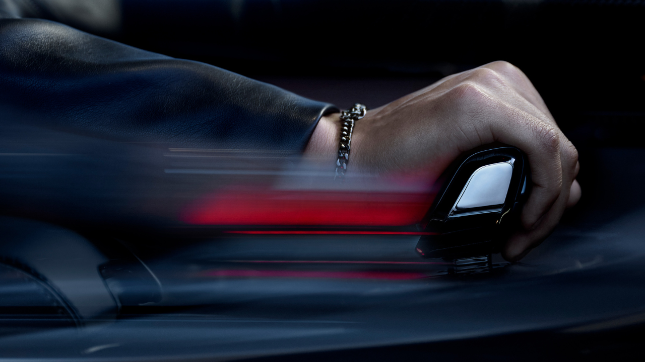 Hand operating automatic gear selector in luxury car.
