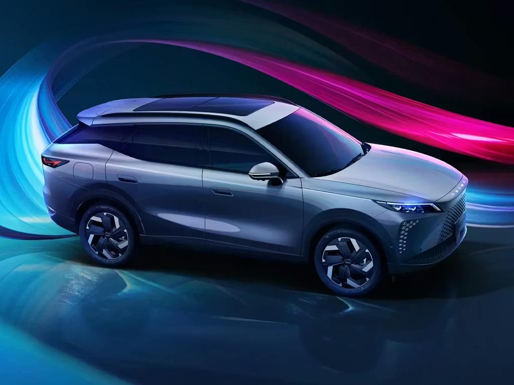 Side profile view of the Omoda 7 SUV in metallic grey, featuring a sweeping roofline, bold geometric alloy wheels and distinctive angular LED headlight signature.